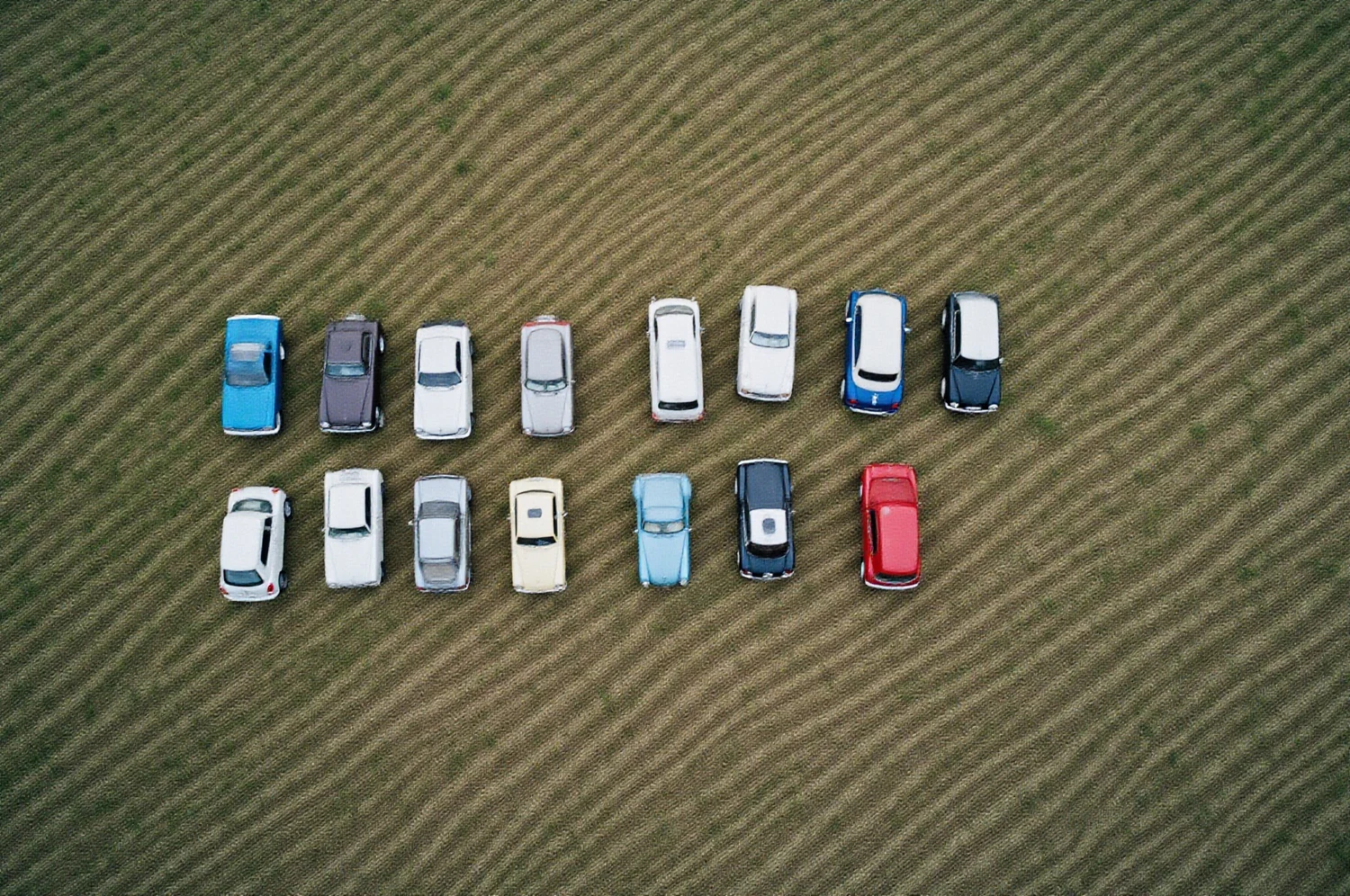 Automašīnu rinda uz zāles, skats no augšas